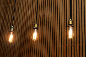 Pendant lamps with light bulbs on wooden background