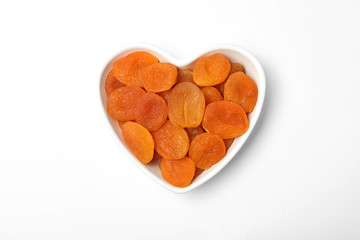 Bowl with dried apricots on white background, top view. Healthy fruit