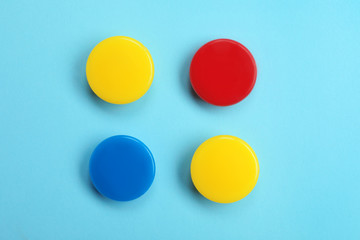 Bright magnets on color background, top view