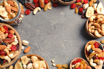Frame of different dried fruits and nuts on color background, top view. Space for text
