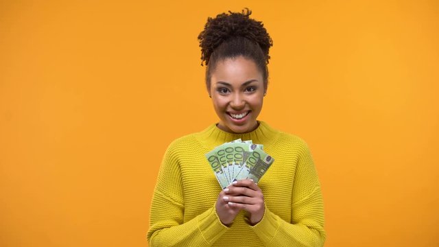 Glad African-American woman holding bunch of euros, high-paying job, salary