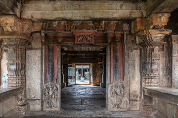 Fototapeta na wymiar Belavadi, Karnataka, India - November 2, 2013: Veera Narayana Temple. Looking through Entrance hall, from street side, to the sanctuary grounds show chiseled pillars and walls. Other side part of flag