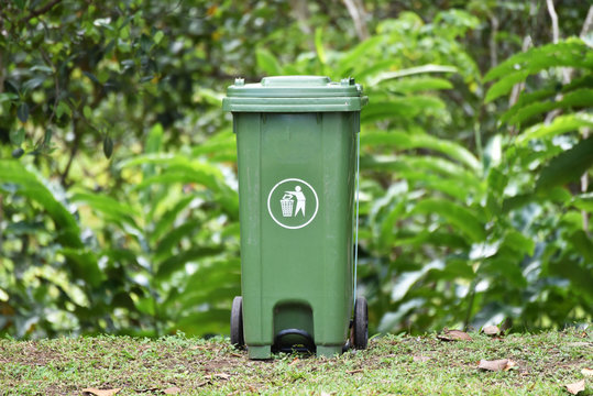 Green recycle bin in the garden park