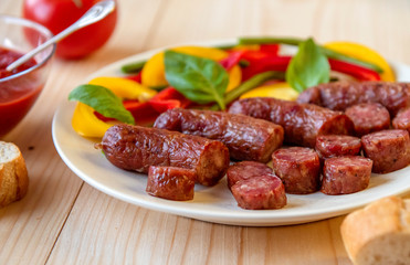 Grilled sausage on a plate on w wooden table