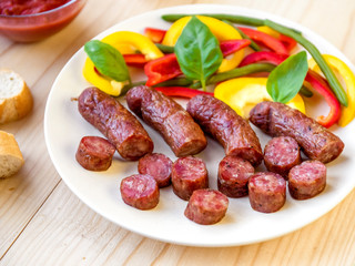 Grilled sausage on a plate on w wooden table