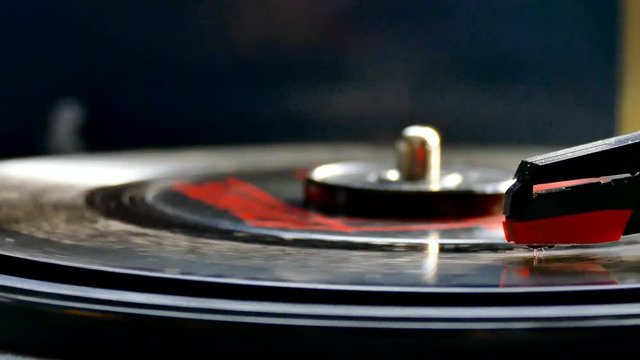 Vinyl Record rotating on retro turntable audio player with focus on needle.