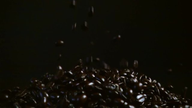 roasted coffee bean falling dark background