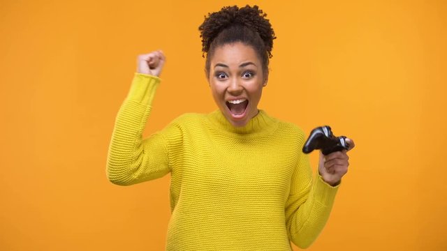 Young african american woman stoutly playing video games with game controller