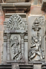 Belur, Karnataka, India - November 2, 2013: Chennakeshava Temple. Gray wall stone sculptures of two Shilabalikas, dancing women.