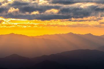 Fototapeta na wymiar Hazy mountain range with dramatic sunset sky