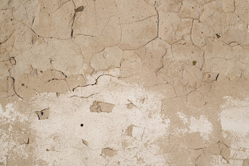 Concrete wall texture with cracked plaster. Weathered uneven rough surface. Perfect for background and grunge design.