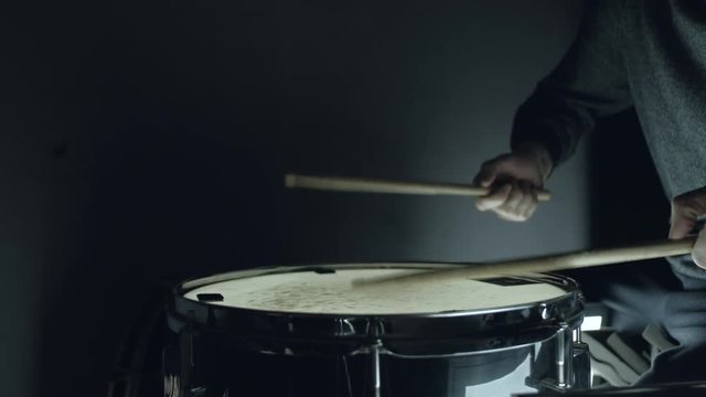 the man plays with sticks on a snare drum, home lesson training