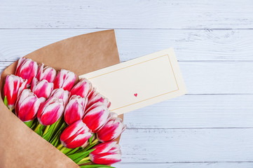 Bouquet of red tulips for the holiday women's day and valentine's day on the background of wooden boards.
