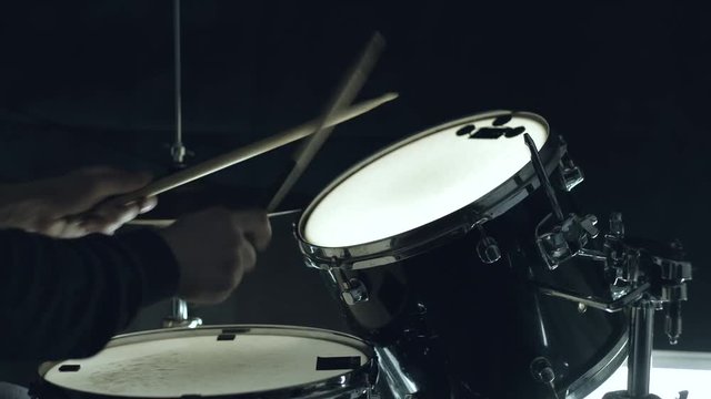 Jazz drummer playing at drums set on concert isolated on black background. 4k. Medium shot.