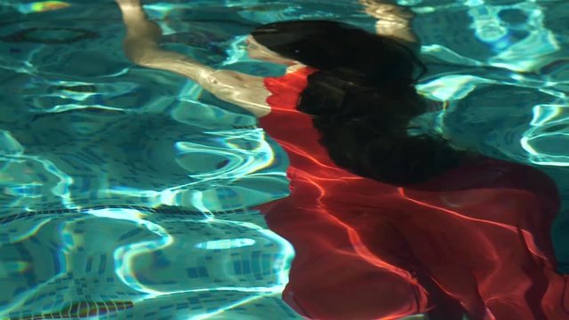 Woman in dress underwater