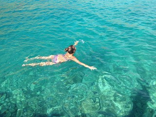 young woman swimming in clear blue water