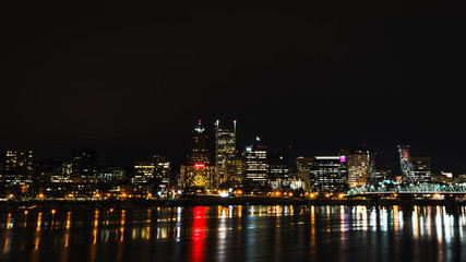 Fototapeta na wymiar Nighttime Cityscape Across Water with Reflections