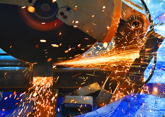 Close up saw machine cutting Steel channel sparks while grinding iron at site construction