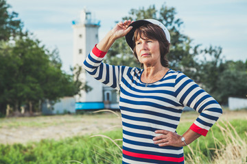 Elderly woman looking into the distance on seashore
