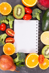 Natural fruits with vegetables as source vitamins and notepad for writing notes, healthy nutrition concept