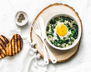Baked spinach eggs - delicious breakfast, brunch, snack on a light background, top view