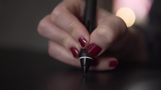 SLOW MOTION: Detail of digital pen in a womans hand on modern graphic tablet
