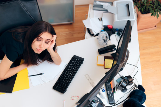 Tired Girl Sitting on Messy Desk Working Overtime 