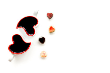 Heart-shaped mugs for Valentine's day and sweets on white background top view space for text