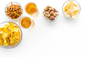 Snacks and beer. Chips, nuts, rusks near beer on white background top view space for text