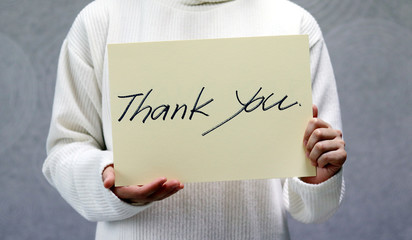 Woman&nbsp;wearing&nbsp;a&nbsp;white&nbsp;sweater,&nbsp;handwritten&nbsp;letter,&nbsp;Thank you