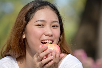 Asian Female Eating With An Apple
