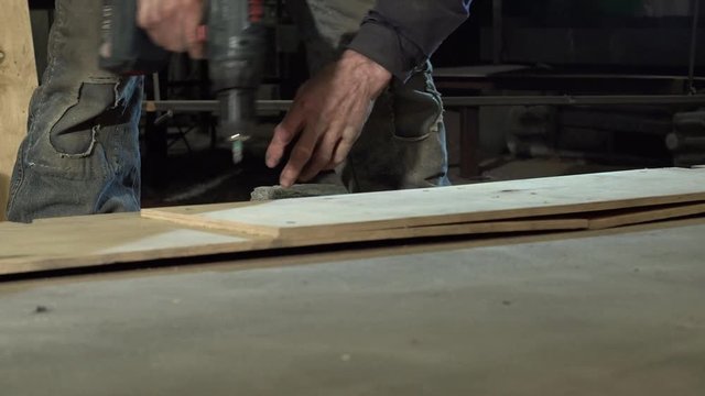 Hands Of A Male Carpenter Carve A Piece Of Plywood