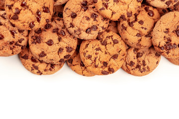 Many freshly baked chocolate chip cookies, shot from above on a white background, an abstract sweet biscuits texture with a place for text