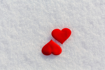 Two red hearts on glittering snow. Vilentine's day theme.