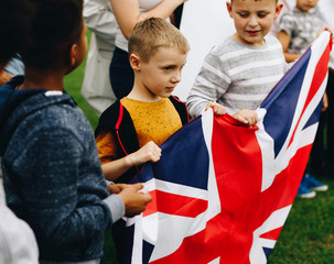 Group of diverse kids showing a UK flag in a protest