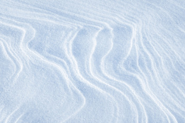Fototapeta na wymiar Winding lines from the wind in the snow. Texture of crusty snow. Winter background.