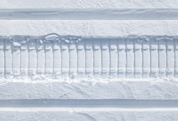 Snowmobile tracks in the fresh snow. Horizontal seamless texture.
