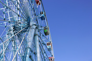 Ferris wheel is rotating on the amusement park.