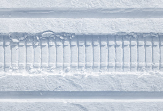 Snowmobile tracks in the fresh snow. Horizontal seamless texture.