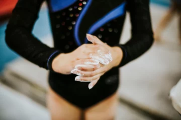 Abwaschbare Fototapete Young gymnast applying a powdered chalk to her palms © Rawpixel.com