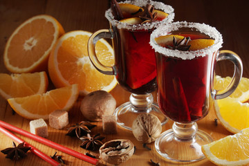 Two cups with ready mulled wine with anise, cinnamon and nuts around