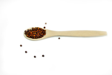 Red peppercorns close up,  in wooden spoon on a white background isolated