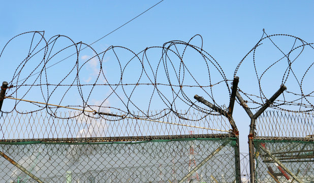 a barbed-wire entanglement and an iron gate