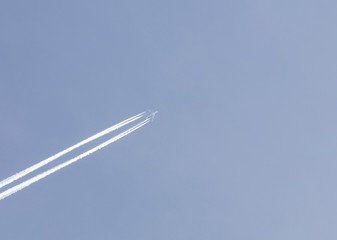 white airplane fly on blue sky background. view from below