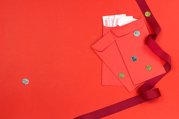 Chinese new year angpao pocket with money inside decorate with red ribbon on red paper background