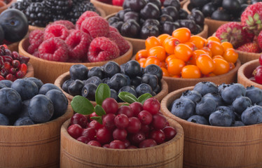 berries in wooden cups background