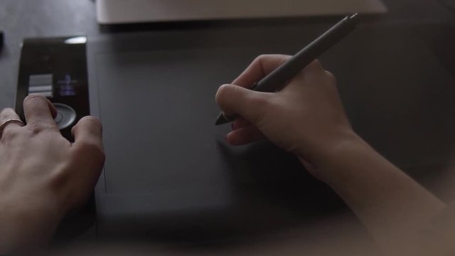 SLOW MOTION: Young talented graphic designer using digital pen to draw