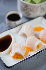 Closeup of steamed chinese har gao with dipping sauces, selective focus, vertical shot