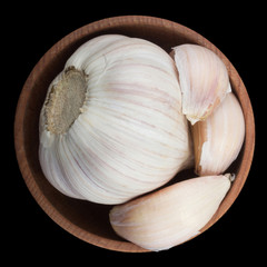 garlic in wooden cup isolated on black background. top view