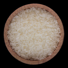 heap of ground coconut chips in wooden cup isolated on black background. top view